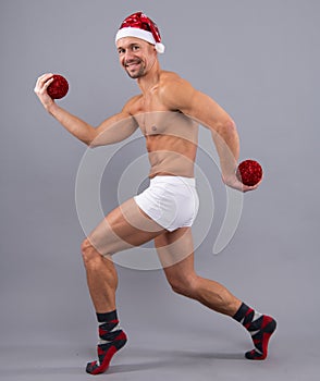 Funny muscular santa in santa hat and white underwear. Christmas and New Year concept. Naked gay santa in santa head