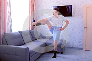 Funny nerd man is doing forward slopes and stretching exercises for legs at home. Sport humor concept.
