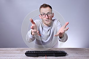 Funny nerd young businessman, man working on computer.Typing on the keyboard programmer in glasses in front of computer