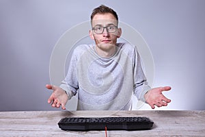 Funny nerd young businessman, man working on computer.Typing on the keyboard programmer in glasses in front of computer