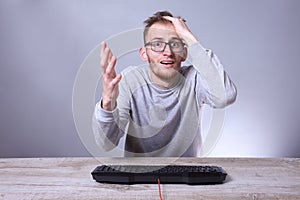 Funny nerd young businessman, man working on computer.Typing on the keyboard programmer in glasses in front of computer