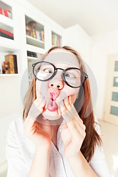 Funny nerdy girl in eyeglasses grimacing