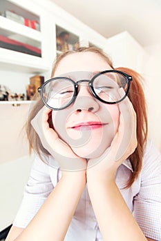 Funny nerdy girl with ponytails in eyeglasses dreaming about holidays