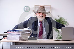 Funny old boss in cowboy hat in the office