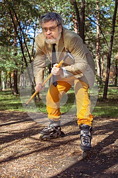 Funny old man on roller skates and walking stick