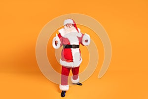 Funny old Santa Claus on yellow studio background. Merry Christmas and Happy New Year! Copy space. Xmas sale, discount concept