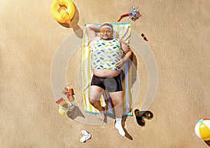 Funny overweight tourist resting on the beach
