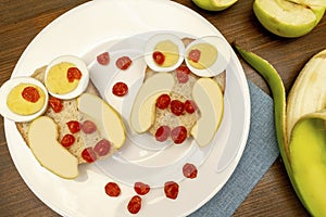 Funny owl face sandwich toast bread with eggs, apple, banana, berry fruits on plate. Cute kids childrens baby's