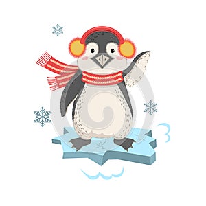 Funny penguin with earmuffs on an ice floe waving. Cute pet.