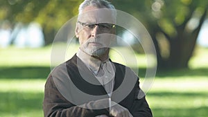 Funny pensioner looking with interest at young woman passing by in park, flirt