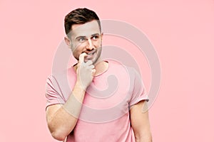 Funny pensive man have doubts making decision looking to copy space on pink background