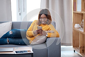 Funny, phone and black woman laughing on sofa with silly chat, text or gif communication at home. Smartphone, joke and