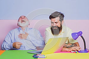 Funny photo of businessman wearing shirt working with laptop at table. Cheerful business men team of two people group