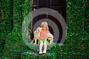 Funny photo of child cuddling beautiful golden labrador retriever puppy