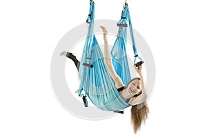 Funny photo from fly yoga or antigravity yoga workouts. Girl weighs in sports hammock and laughs. Isolated on white background