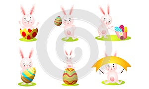 Funny pink rabbits playing with colored eggs vector illustration