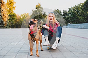 Funny playful dog and her female owner on the skateboard, selective focus.