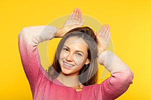 Funny playful girl fooling around faking ears palm photo