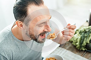 Funny pleasant man opening mouth and eating.