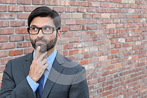 A funny pondering businessman with glasses looking away with copy space