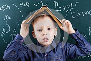 Funny portrait clever pupil boy on school board background