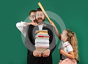 Funny portrait of comic father tutor and crazy students schoolkids on green blackboard background. Bad teacher.