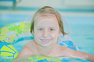 Funny portrait of happy cute little child girl at swimming pool