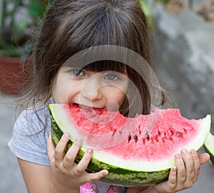 Funny portrait of an incredibly beautiful little girl blue eyes, eating watermelon, healthy fruit snack,