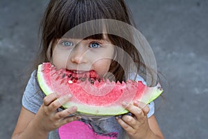 Funny portrait of an incredibly beautiful little girl blue eyes, eating watermelon, healthy fruit snack,