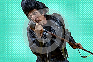 Funny portrait of mature rocker. An old singer dressed in rockabilly style in action