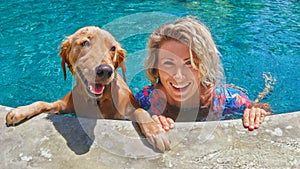 Funny portrait of smiley woman with dog in swimming pool