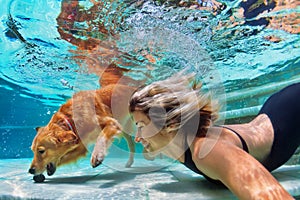 Funny portrait of smiley woman with dog in swimming pool