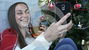 Funny portrait of smiling girl photographing herself by smartphone