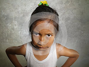 Funny portrait of sweet angry and mad 8 or 9 years old child looking upset to the camera feeling and unhappy isolated on