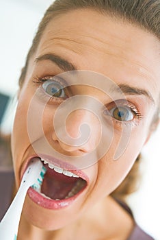 Funny portrait of woman intensively brushing teeth photo