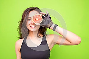 Funny portrait of young brunette fitness woman holding fresh pink grapefruit. Healthy eating lifestyle and weight loss concept.Bea