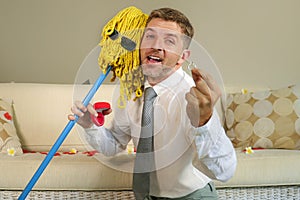 Funny portrait of young weird crazy and happy man holding mop with sunglasses as if it was his fiance kneeling and proposing marri