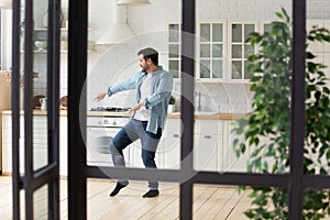 Funny positive man dancing in modern kitchen alone