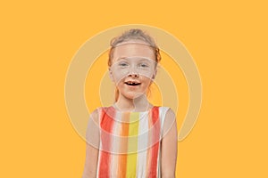 Funny positive toothless blonde girl. Bright multi-colored dress.