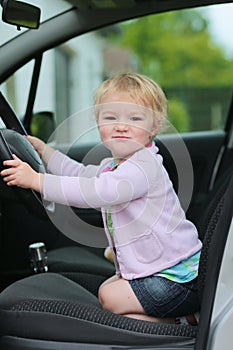 Funny preschooler girl playing in the car