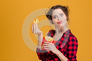 Funny pretty young woman making fake moustache with fries