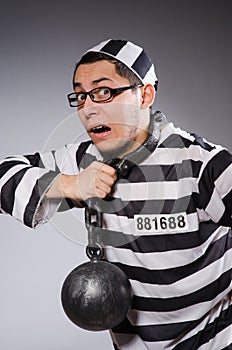 Funny prisoner in chains isolated on gray