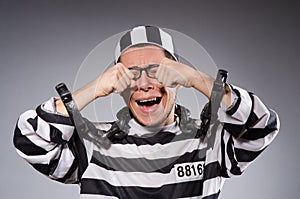 Funny prisoner in chains isolated on gray