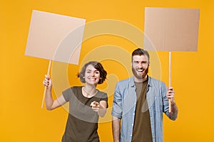 Funny protesting two people guy girl hold protest signs broadsheet blank placard on stick pointing finger on camera