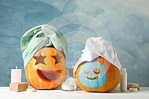 Funny pumpkins and skin care accessories on white background