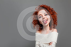 Funny red curly girl with big head shows tongue. Caricature stylization of female logic