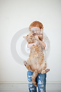 Funny red-haired boy with a cat