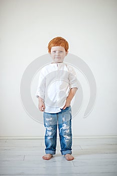 Funny red-haired boy in a shirt and jeans