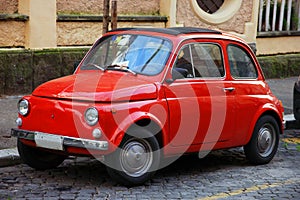 Funny red small old little italian car with round headlights and