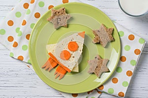 Funny sandwich with cheese and carrots in a shape of rocket and stars, meal for kids idea